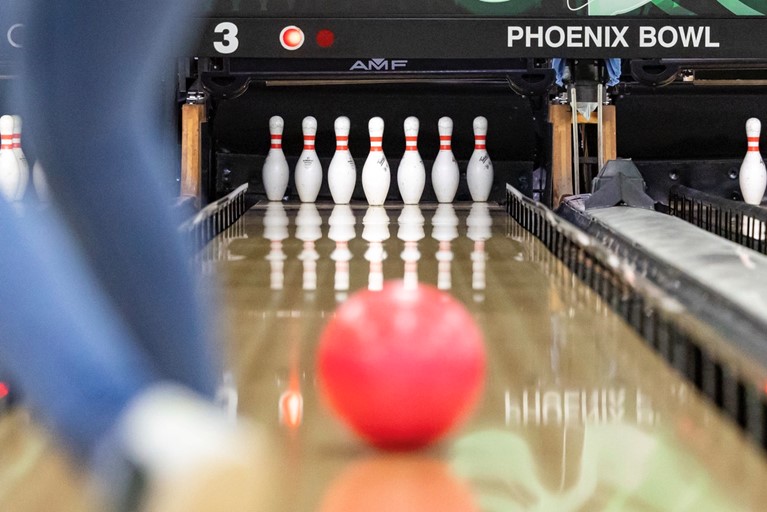 Bowling pins lined up with a ball rolling towards them at Phoenix Bowl
